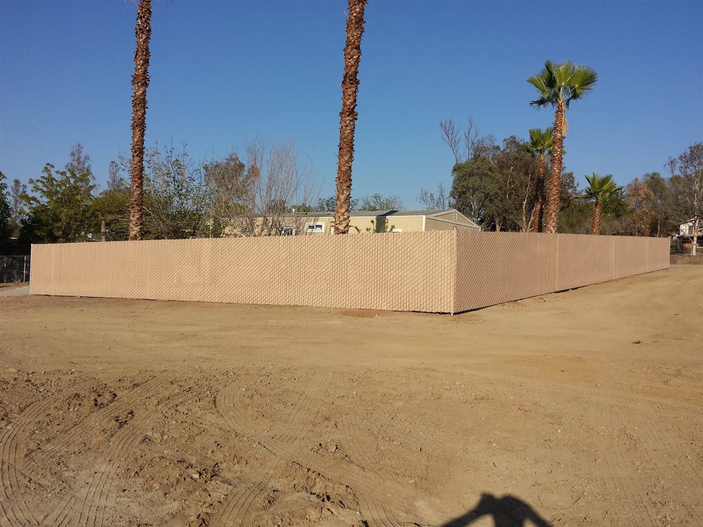 Corner run of chain link fence with tan privacy slats