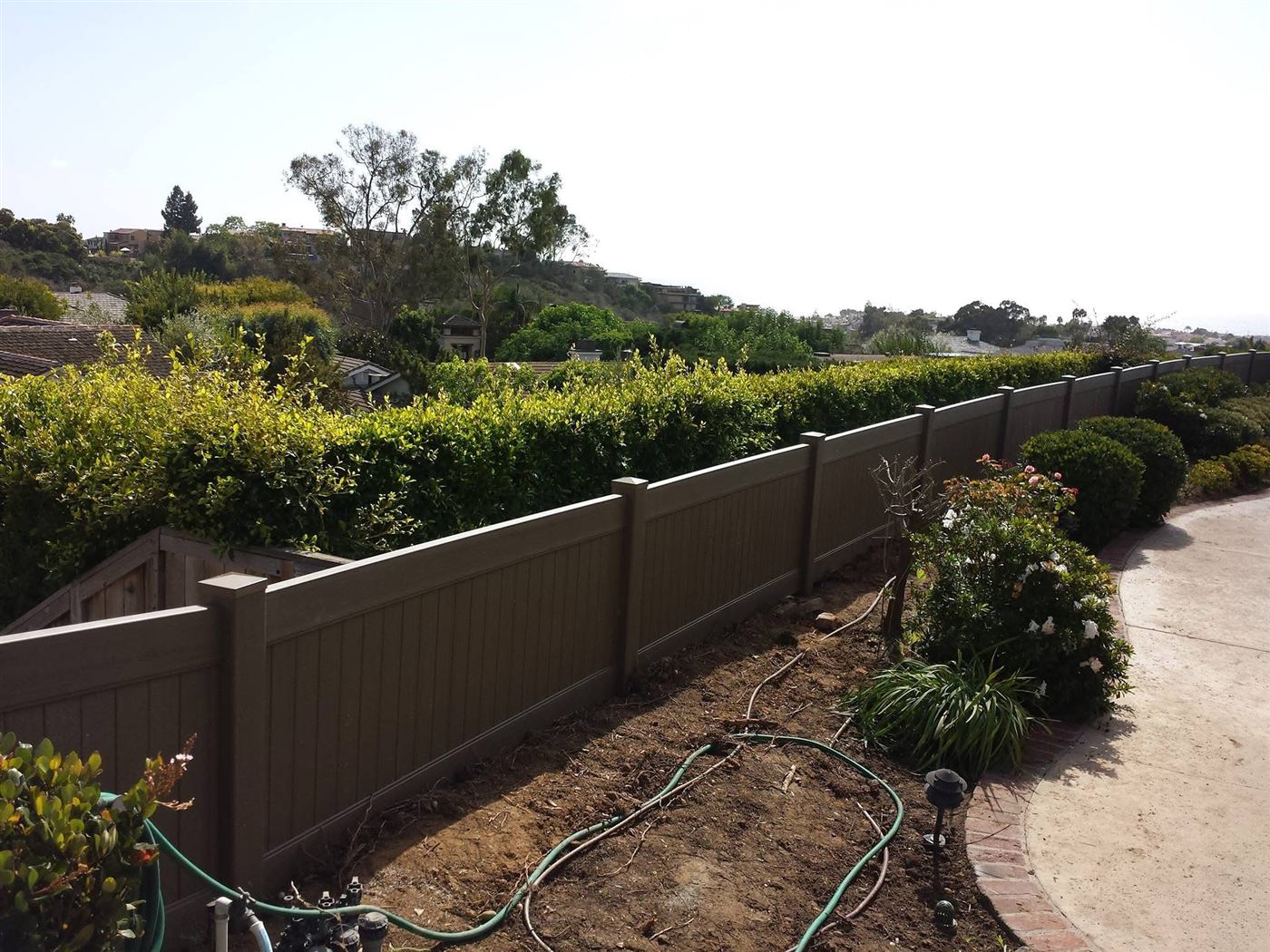 Vinyl privacy fence along a landscaped backyard
