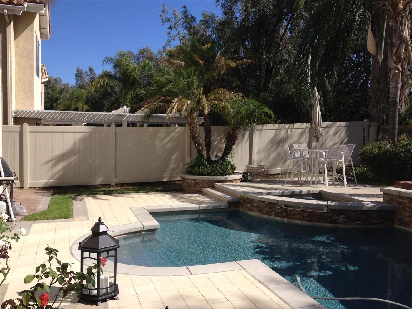 Solid vinyl privacy fence around a backyard pool